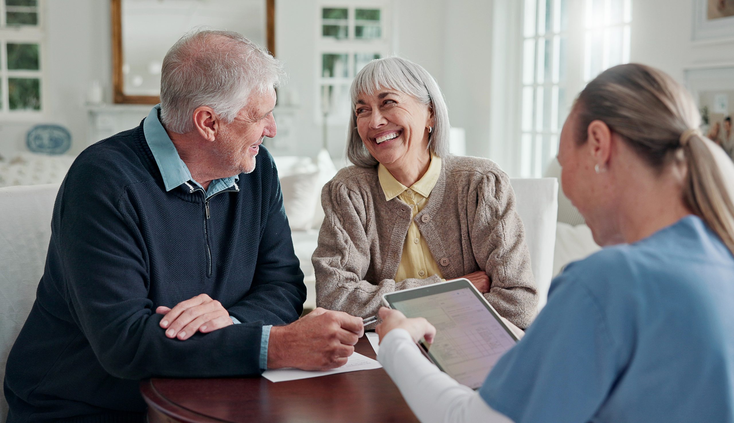 Happy, old couple and caregiver in home